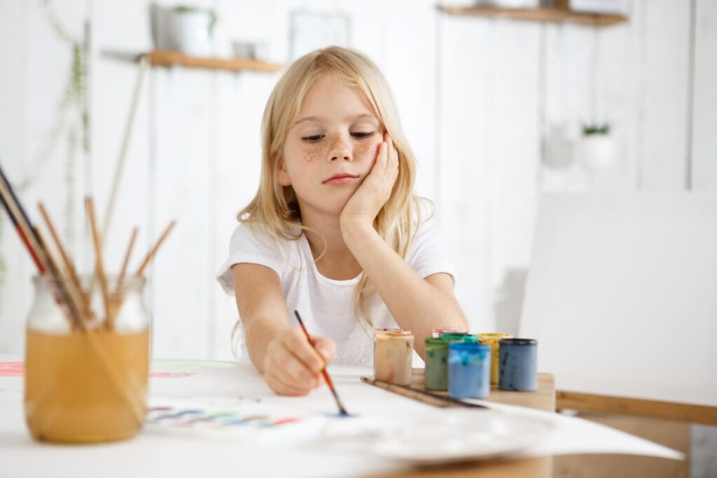 Hoogbegaafd kind dat geconcentreerd schildert en verdiept is in creatieve activiteit