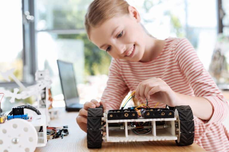 Hoogbegaafd kind dat geconcentreerd een robot bouwt en experimenteert met techniek