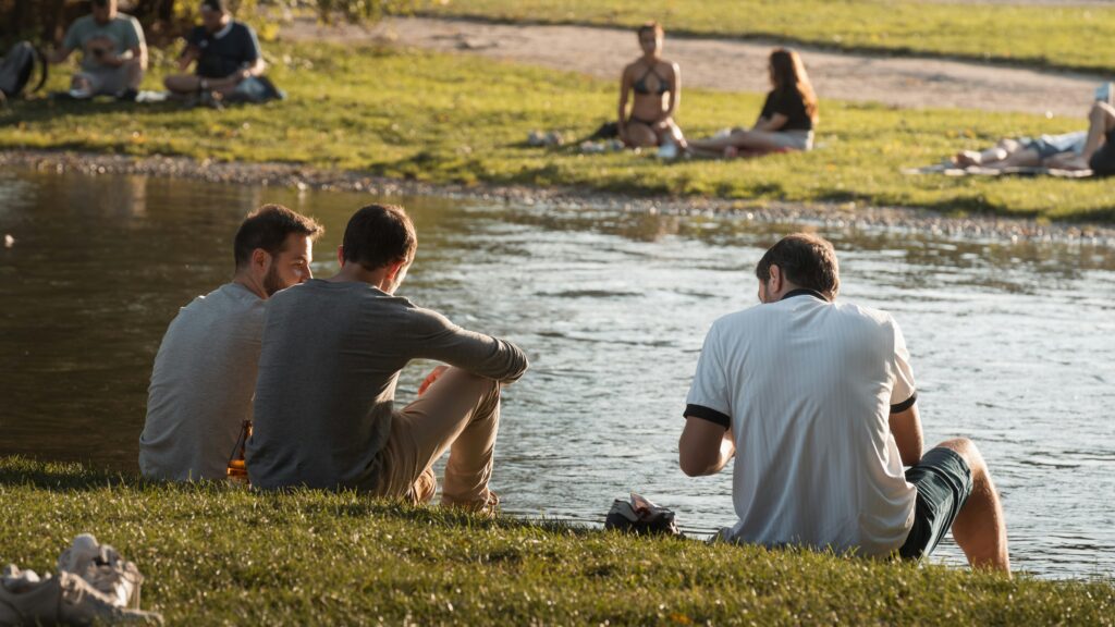 Drie mensen in gesprek aan het water als beeld voor hoogbegaafdheid en relaties
